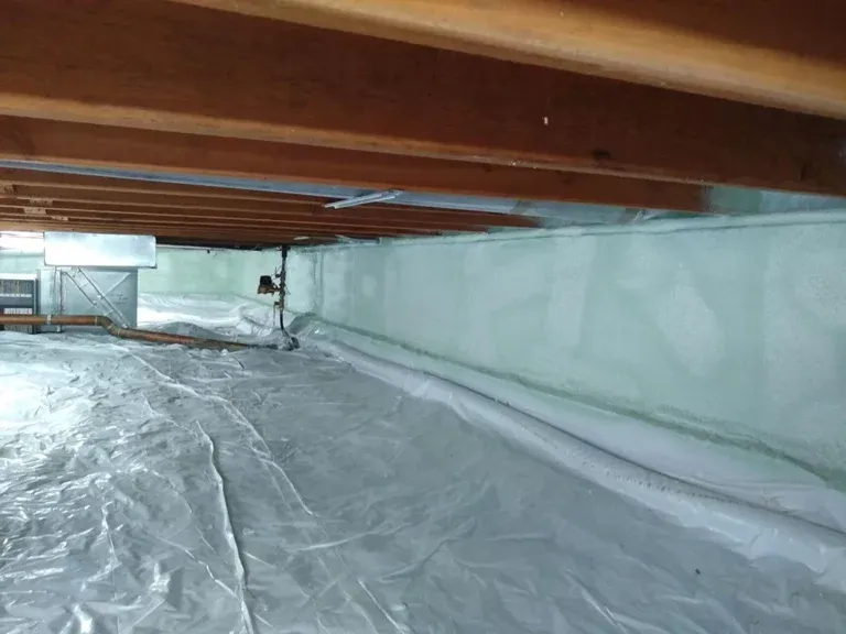 Crawl space encapsulated with spray foam on the foundation walls and a vapor barrier over the ground