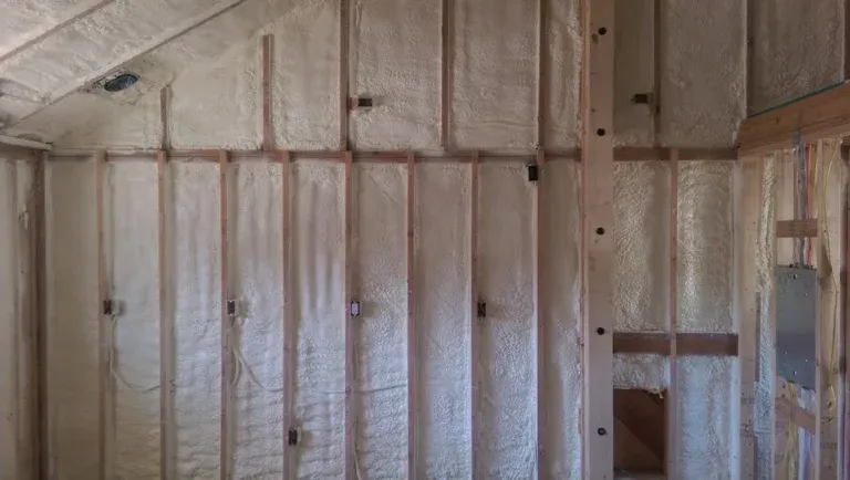 Spray foam insulation applied between wood wall studs during new construction